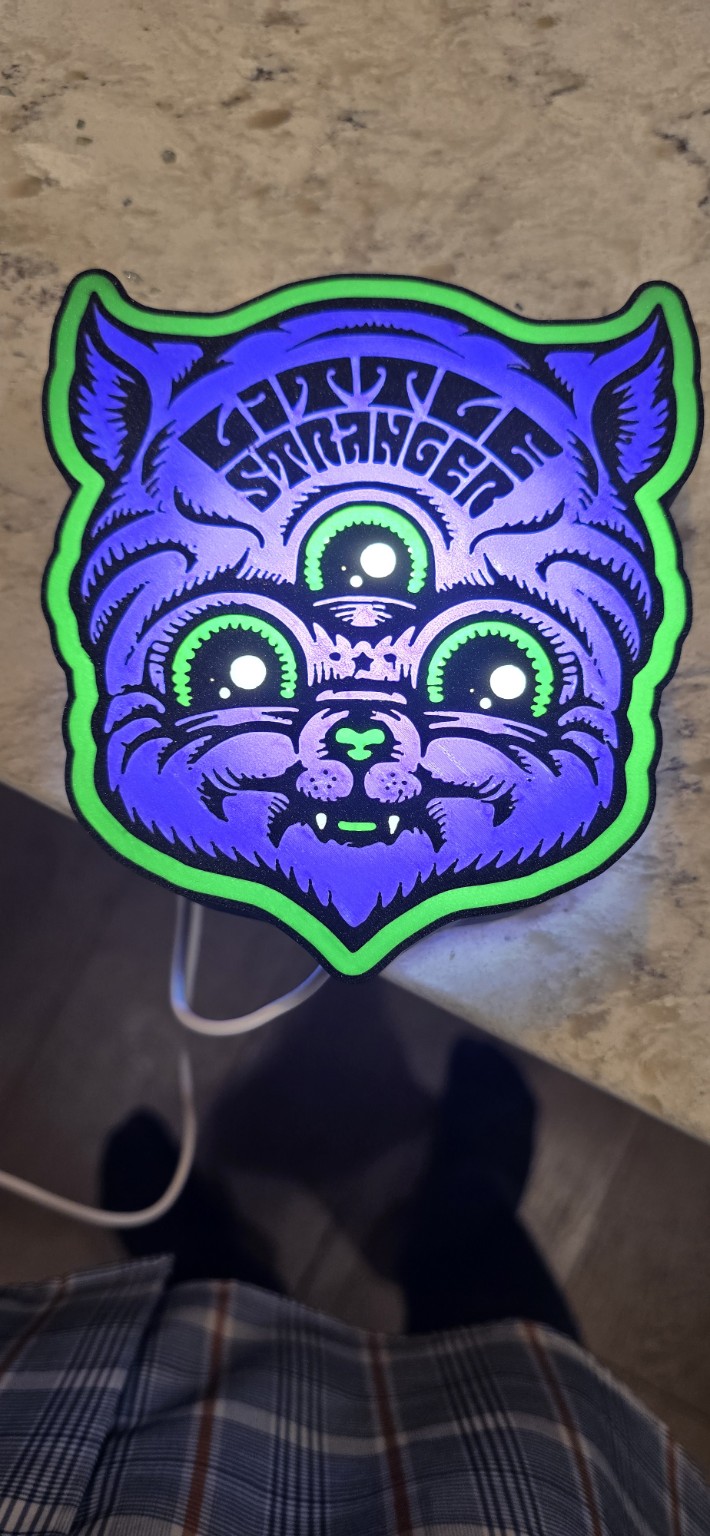 Illuminated purple three-eyed cat wall art