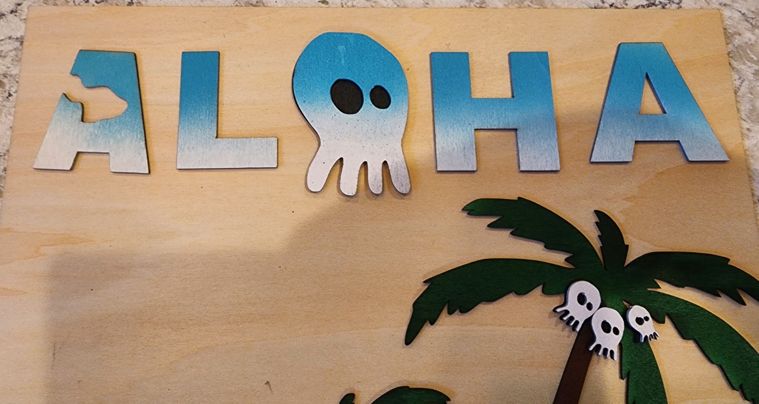 Engraved Aloha sign with skull lettering and palm trees