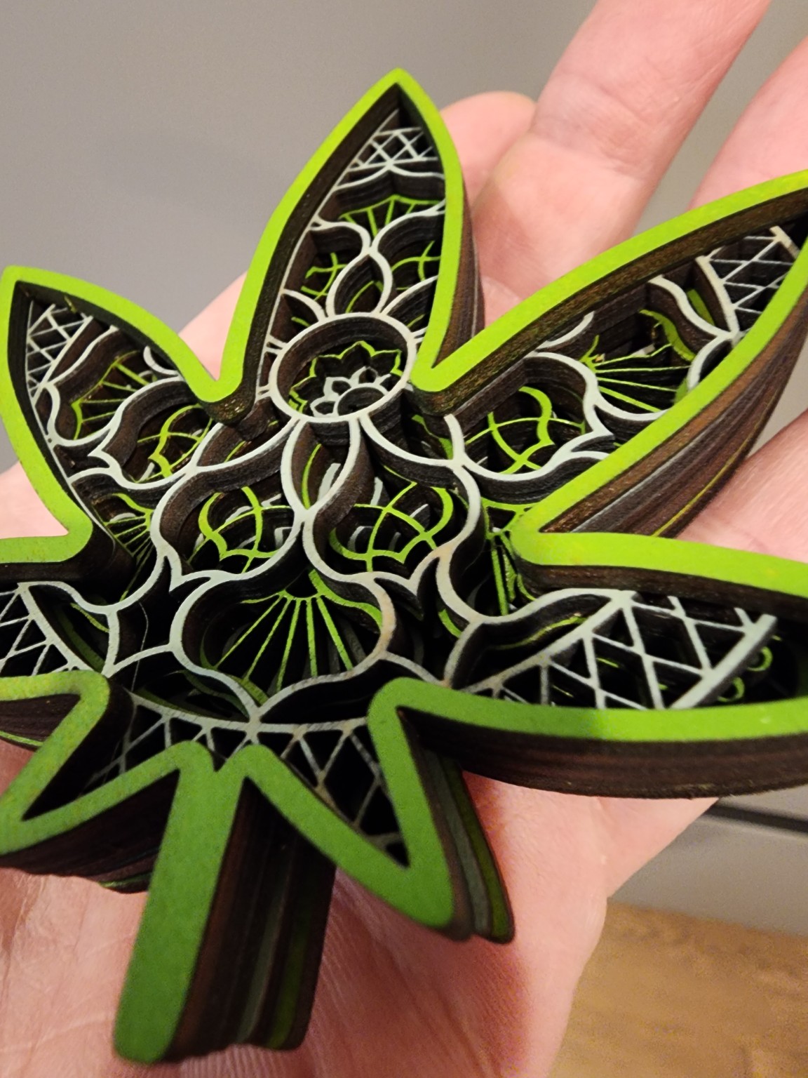 Green and black layered leaf artwork with engraved patterns