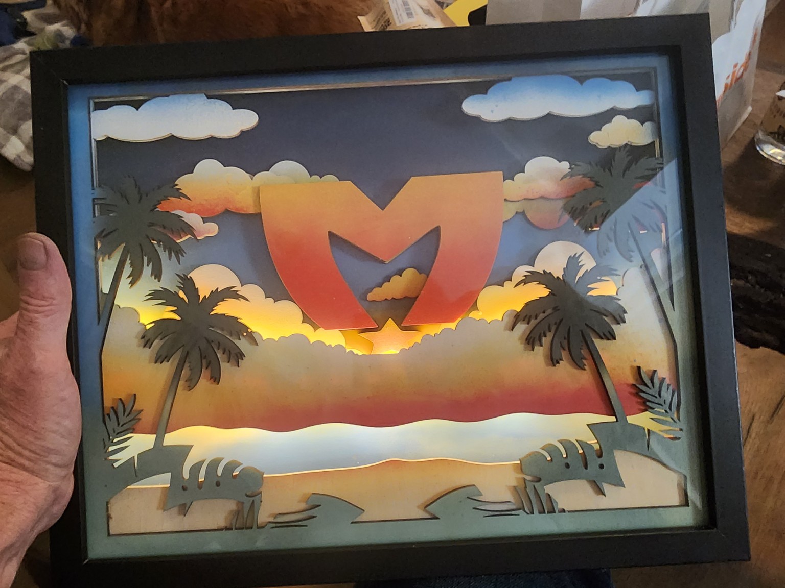 Colorful layered tropical sunset scene in a black shadowbox