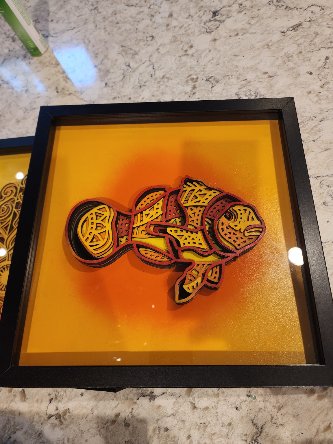 Colorful layered sea turtle artwork in a black frame